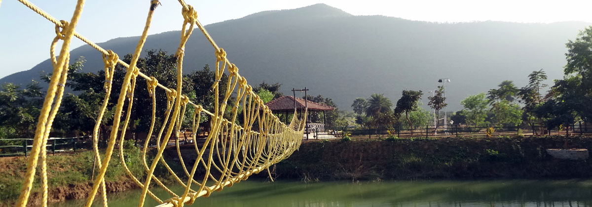 A rope bridge across a large pond situated inside the resort